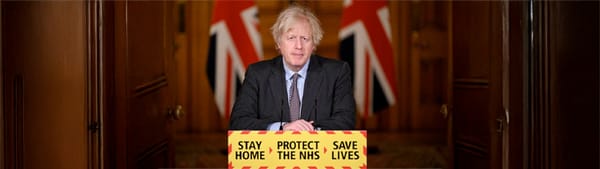 Boris Johnson stands at a podium looking like an absolute wanker.